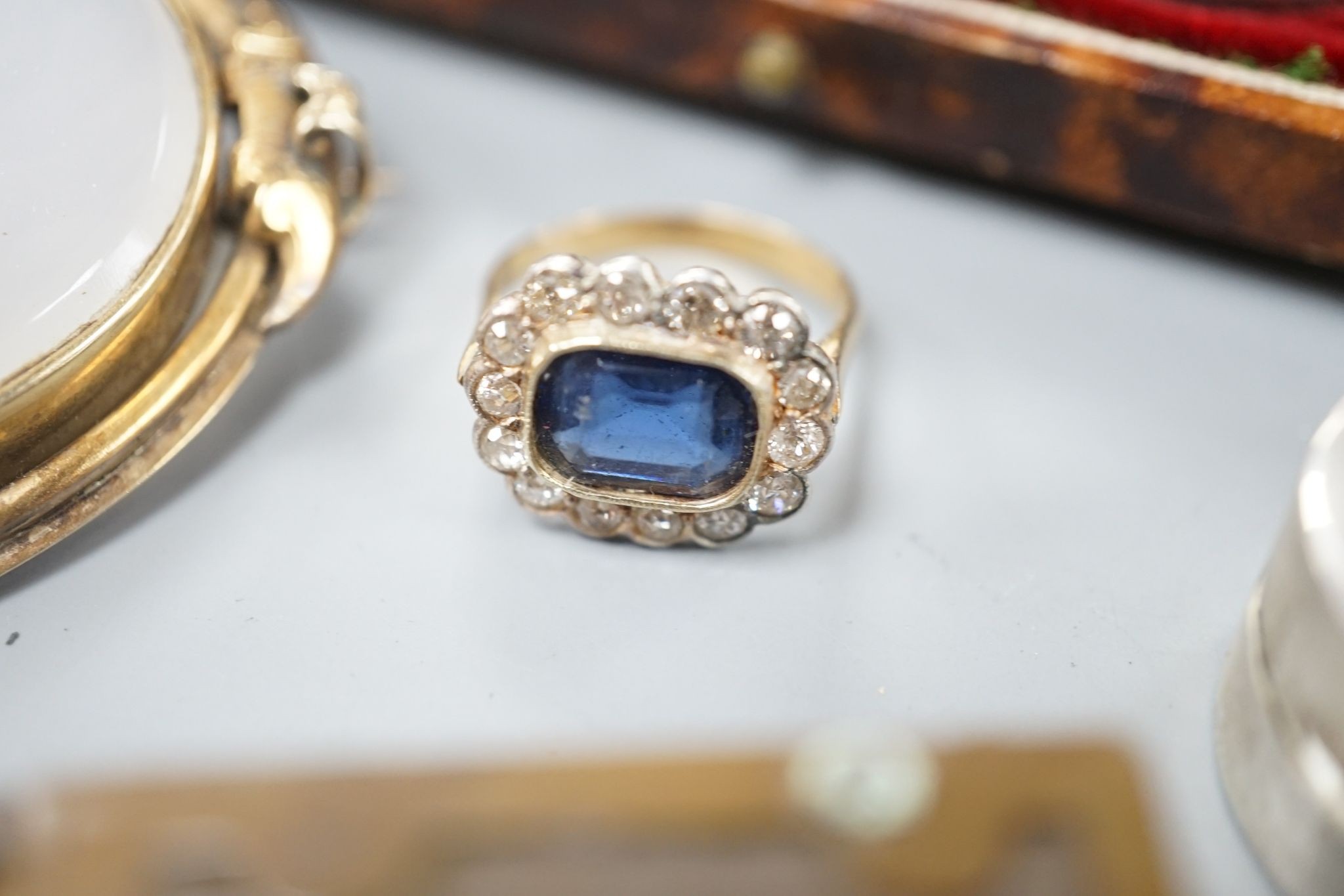A 9ct mounted oval cameo shell brooch, 47mm, a yellow metal blue paste and diamond cluster set ring, size L, three 9ct rings and other items including silver vesta case, silver bangle and costume jewellery etc.